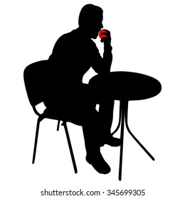 Young man sitting at the table and eating a fresh apple