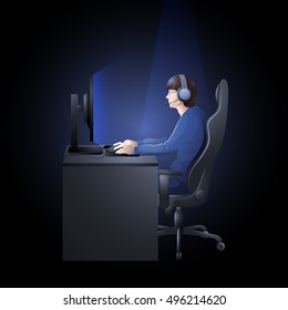 Young man sitting at the table and playing computer. Side view. Cyber sport concept.