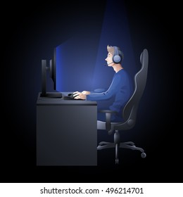 Young man sitting at the table and playing computer. Side view. Cyber sport concept.