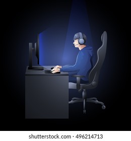 Young man sitting at the table and playing computer. Side view. Cyber sport concept.