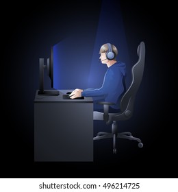Young man sitting at the table and playing computer. Side view. Cyber sport concept.