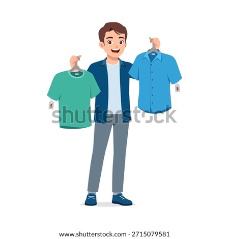 Young man smiling happily while holding two different shirts with price tags choosing clothes for shopping