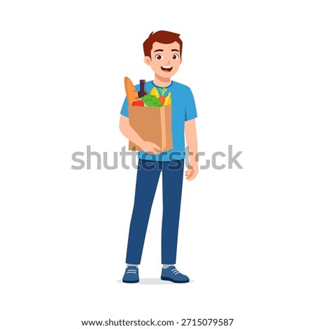 Young man smiling holding a grocery paper bag full of fresh food items after shopping happy mood