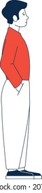 Young man standing with hands in pockets. Side view