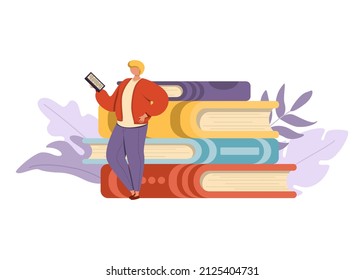 Young man is standing next to a stack of giant books and reading.