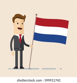 A Young Man Stands With Netherlands Flag In His Hand. Businessman In Suit With Holland Flag In Hand. Vector, Illustration, Flat