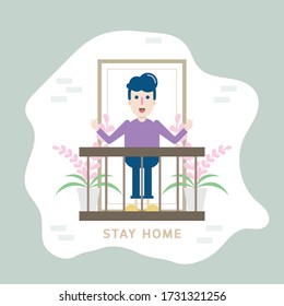 A young man stands on the balcony of the house with plant pots to keep their distance. Stay at home in the quarantine area during the coronavirus epidemic.