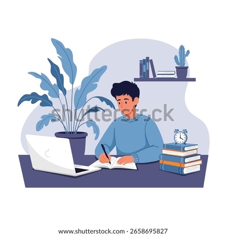 A young man is studying at his desk, writing in a notebook with a laptop, books, and a plant nearby.