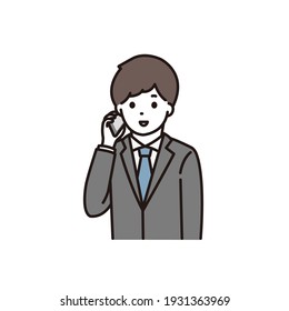 A young man in a suit calling with a smile on his smartphone