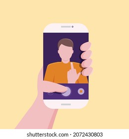 A young man taking a picture of himself with a cell phone holding up his middle finger.
Illustration about take a photo of yourself.