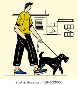 Young man walking with black dog. Happy man taking dog on a walk. Smiling man walking a dog on a leash