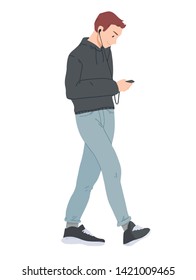 Young man walking and looking at smartphone.