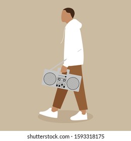 A young man is walking with a tape recorder in his hand