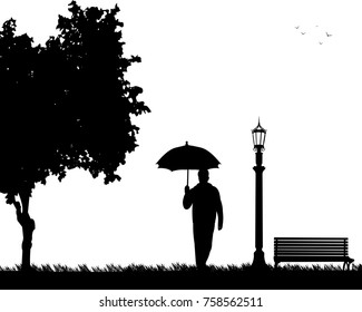 Young man walking under the umbrella in park in autumn or fall, one in the series of similar images silhouette