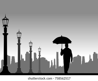 Young man walking under the umbrella on the street in autumn or fall, one in the series of similar images silhouette