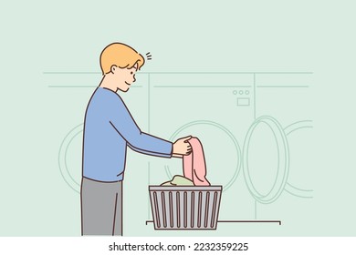 Young man washing clothes in laundry. Smiling guy with dirty clothing in laundromat room. Hygiene concept. Vector illustration. 