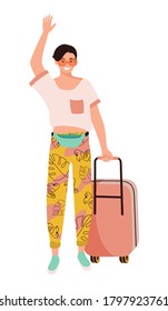 A young man wearing glasses and fashionable clothes stands with a suitcase and waving his hand.
