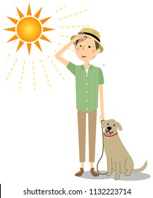 Young man wearing a hat walking a dog