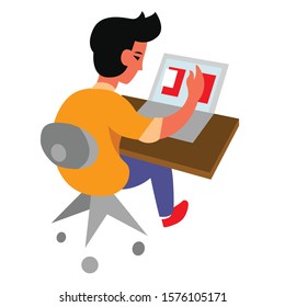 Young man working on a computer at a desk.
