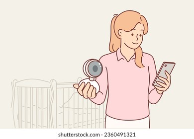 Young mother holds camera or video babysitter and phone to watch baby sleeping in cradle while walking or working. Smiling woman uses video babysitter and modern technology to facilitate child safety