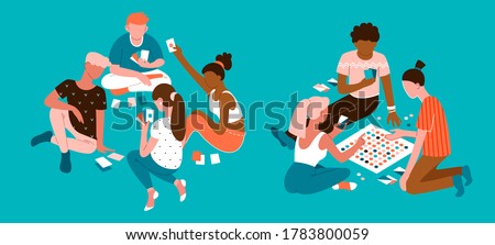 Young multiethnic people having fun at home party and playing card board games on the floor in socks