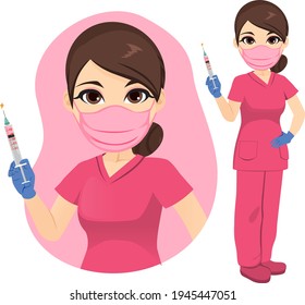 Young nurse in pink uniform holding Covid-19 vaccine and wearing medical face mask