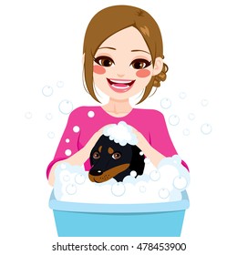 Young professional pet groomer washing dachshund dog