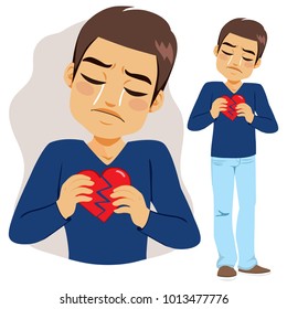 Young sad man holding two pieces of broken heart crying 