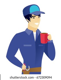 Young smiling asian mechanic holding cup of coffee. Smiling mechanic drinking coffee. Happy mechanic with cup of coffee. Vector flat design illustration isolated on white background.