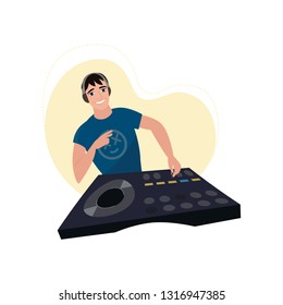 Young smiling male DJ in headphones at console with vinyl record shows victory hand with beige light chaser
