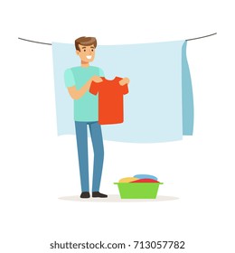 Young smiling man hanging wet clothes out to dry, house husband working at home vector Illustration