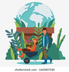 Young and smiling man pushing his laughing girlfriend in a wheelbarrow. Summer landscape background. Eco friendly ecology concept
