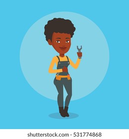 Young smiling repairman standing with a spanner in hand. An african-american repairman giving thumb up. Female repairman in overalls holding a spanner. Vector flat design illustration. Square layout.