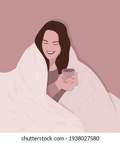 Young smiling woman having a bad cold or flu wrapped in a warm blanket holding a cup of hot tea or coffee, staying in bed concept