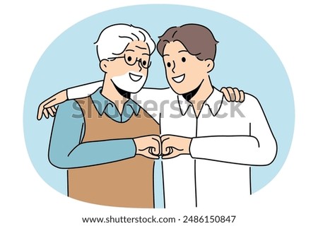 Young son and elderly father hug and bump fists to demonstrate unity and friendship between generations. Man of different ages say together we are strength, calling to be friends for generations