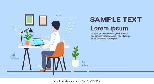 young student sitting at desk using laptop schoolboy doing homework e-learning education concept flat full length rear view horizontal copy space