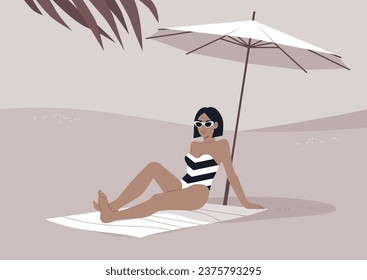 A young stylish woman relaxes on the sandy shore beneath a white beach umbrella, enjoying her summer getaway amidst the sweltering tropical heat