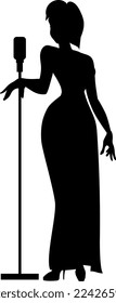 A young talented singer in an elegant long black dress sings a beautiful song about great and bright love.  Silhouette