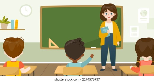 Young teacher leads the lesson in front of the blackboard. Classroom with teacher and studying pupils.