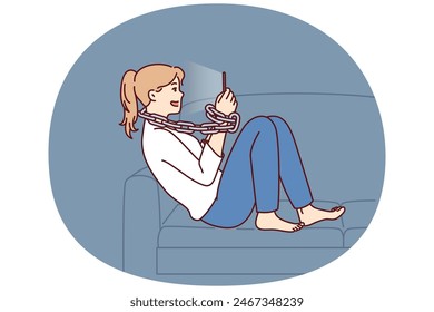 Young woman addicted to mobile phone sitting on sofa with chain around neck. Introverted girl procrastinates using gadgets and suffers from addicted causing loneliness and lack of friends