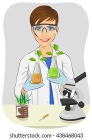 Young woman biologist in white coat holding two flasks with plants next to microscope in laboratory