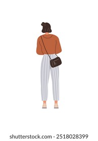 A young woman with brown hair in a bun wears a brown top, high-waisted striped pants, and a small black crossbody bag while walking away. Ideal for fashion, casualwear, lifestyle, city life