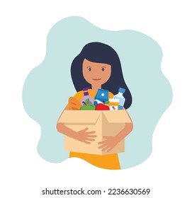 Young woman carries a box of food. Social care, volunteering and charity concept.