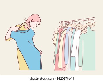 Young woman choosing blouse in the clothes shop. Hand drawn style vector design illustrations.