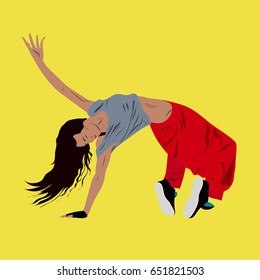 Young woman dancing hip-hop or break-dance on the floor,yellow background