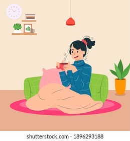 Young woman drinking coffee and chilling on warm cozy blanket in home.