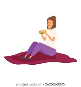 Young woman enjoying a sandwich while relaxing on a picnic blanket