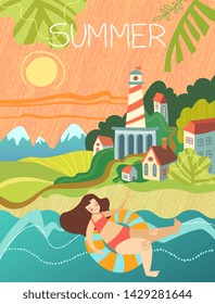 Young woman enjoying a seaside vacation in summer swimming on a tube in the ocean on a hot sunny day with lighthouse and small town nestling in green trees in the mountains conceptual of the seasons