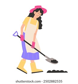 A young woman in garden clothes digs the ground with a shovel