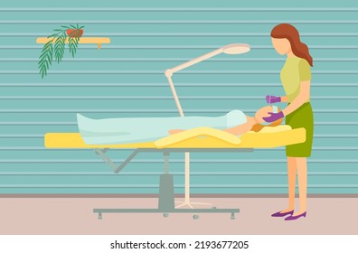 Young woman getting facial massage in spa salon. Professional masseuse and female client lying on table covered with towel. Facial procedures, body care concept. Lady during massage of face